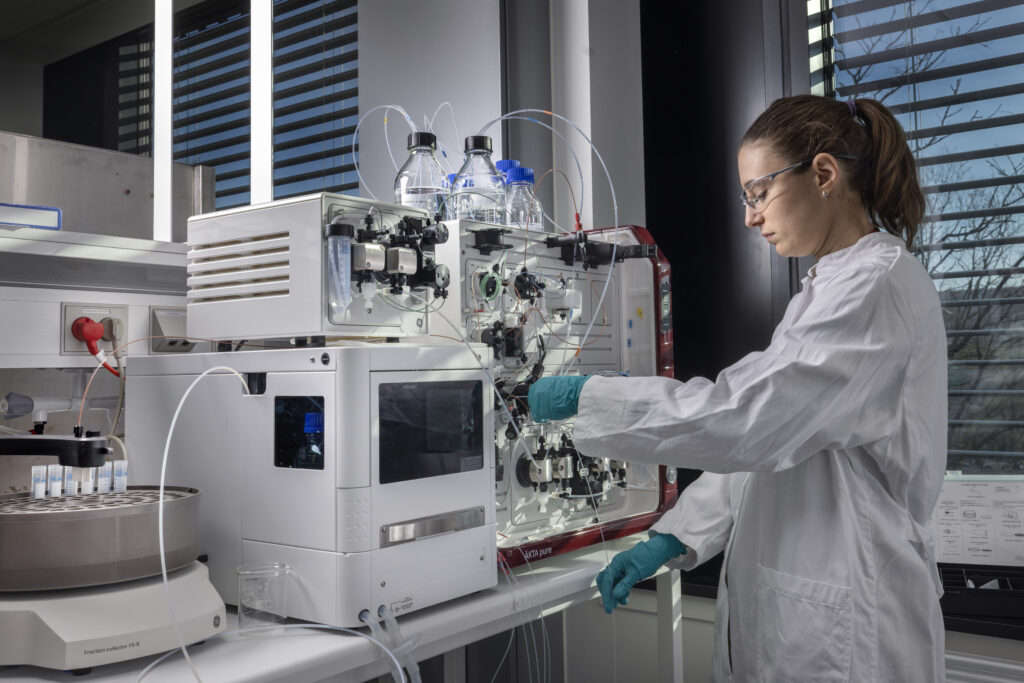 A DTU Chemical Engineering postdoc prepares the ÄKTA pure protein purification system for a run.
